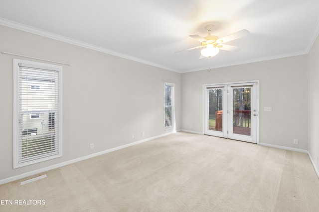 carpeted spare room featuring ceiling fan, plenty of natural light, and ornamental molding