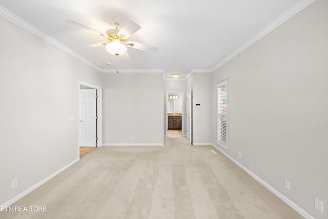 carpeted spare room with ceiling fan and ornamental molding