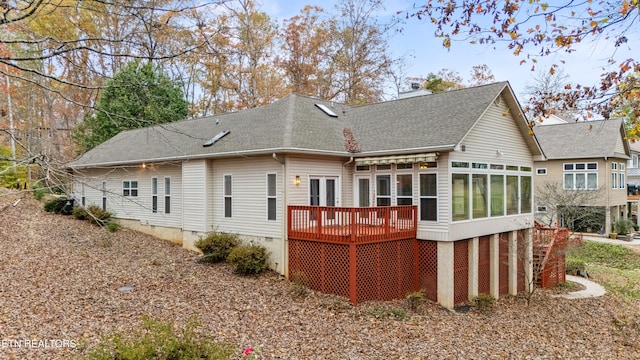 rear view of property with a deck and a sunroom