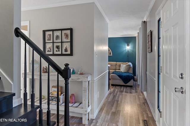 foyer entrance featuring visible vents, wood finished floors, stairway, crown molding, and baseboards