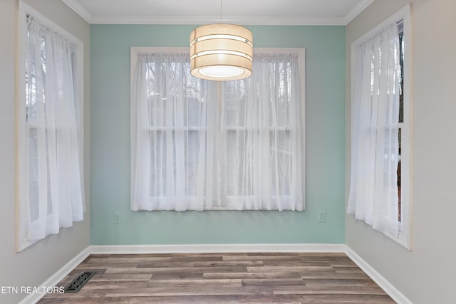 unfurnished dining area with a healthy amount of sunlight, baseboards, and wood finished floors