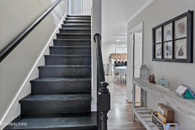 stairs featuring recessed lighting, wood finished floors, and ornamental molding