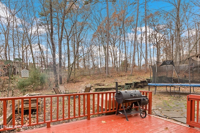 wooden deck with grilling area and a trampoline