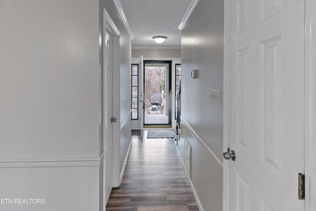 entryway with visible vents, a textured ceiling, wood finished floors, and ornamental molding