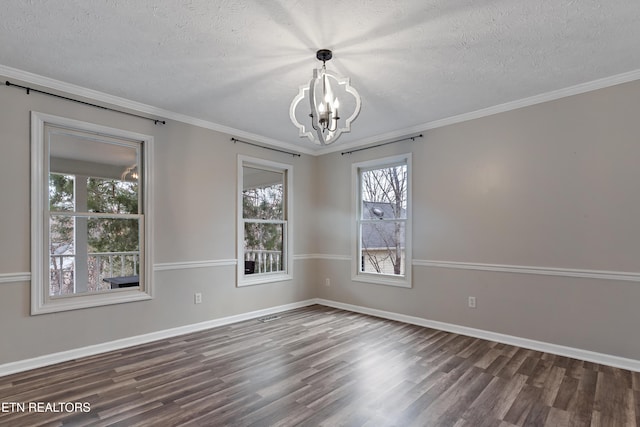 unfurnished room with a textured ceiling, wood finished floors, an inviting chandelier, crown molding, and baseboards