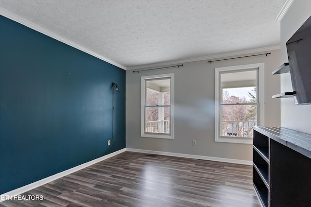 unfurnished living room featuring a textured ceiling, baseboards, dark wood-style flooring, and ornamental molding