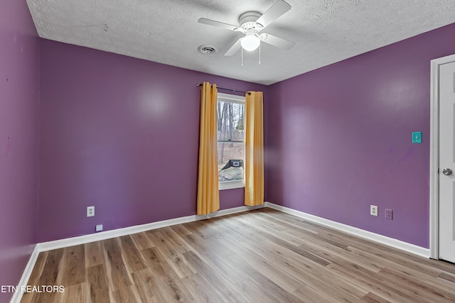 unfurnished room featuring visible vents, baseboards, a ceiling fan, and wood finished floors