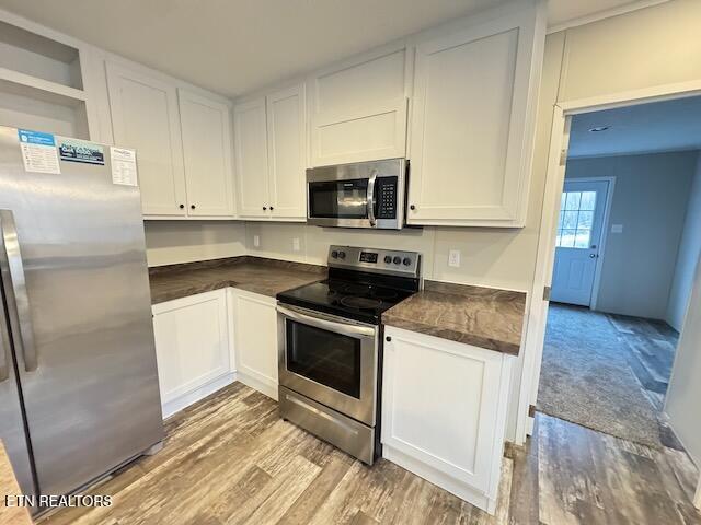 kitchen featuring white cabinets, light hardwood / wood-style floors, and appliances with stainless steel finishes