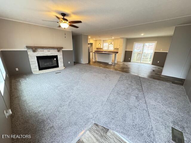 unfurnished living room featuring dark hardwood / wood-style floors and ceiling fan