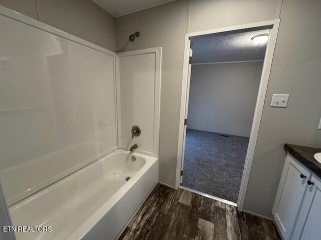 bathroom featuring wood-type flooring, vanity, and shower / tub combination