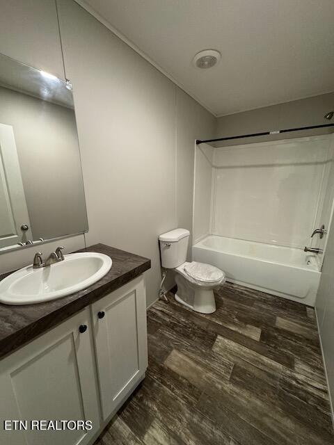 full bathroom with wood-type flooring, vanity, toilet, and shower / washtub combination