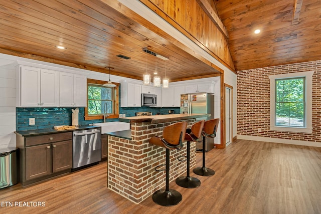 kitchen with white cabinets, stainless steel appliances, a wealth of natural light, and wood ceiling