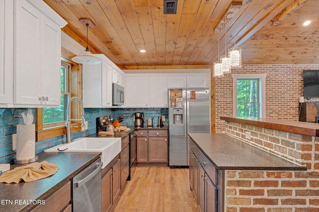 kitchen with white cabinets, a healthy amount of sunlight, and stainless steel appliances