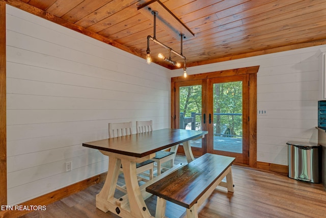 dining area featuring hardwood / wood-style floors, wood walls, french doors, and wooden ceiling