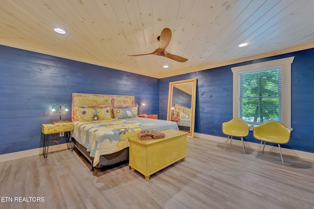 bedroom featuring light hardwood / wood-style flooring, ceiling fan, wooden ceiling, and wood walls