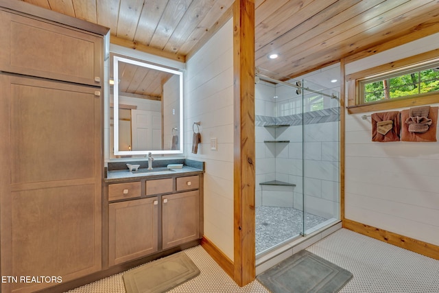 bathroom with vanity, wooden walls, a shower with shower door, and wooden ceiling