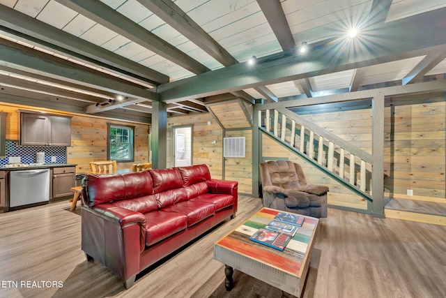 living room featuring wood walls, beam ceiling, and light hardwood / wood-style flooring