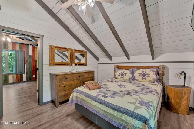 bedroom featuring hardwood / wood-style flooring, lofted ceiling with beams, wood walls, and ceiling fan