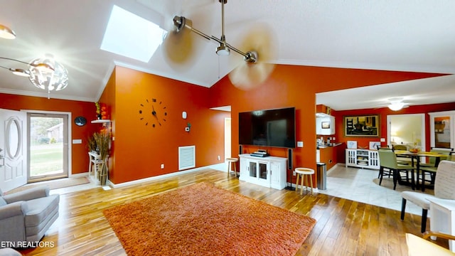 living room featuring lofted ceiling with skylight, hardwood / wood-style floors, and crown molding