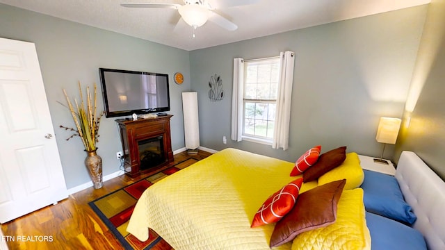 bedroom with ceiling fan and dark hardwood / wood-style flooring