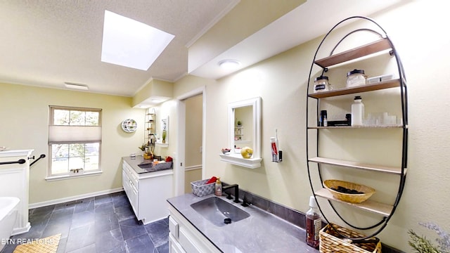 13 Windsor Pt, Crossville, TN 38558 - full bathroom featuring two vanities, a skylight, a tub to relax in, stone finish flooring, and crown molding