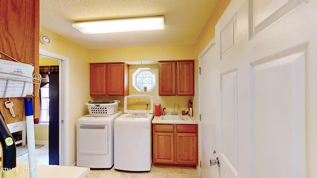 laundry area featuring cabinets, washing machine and dryer, a wealth of natural light, and sink