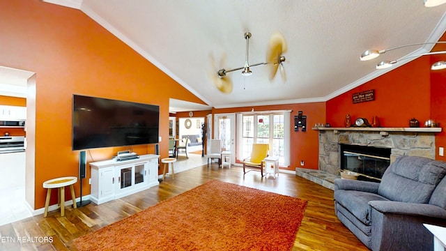 living room with high vaulted ceiling, hardwood / wood-style flooring, ornamental molding, a fireplace, and a textured ceiling