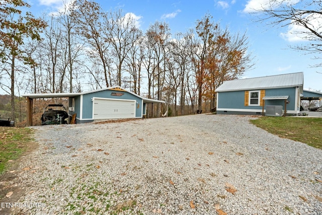 exterior space featuring an outbuilding, cooling unit, a carport, and a garage