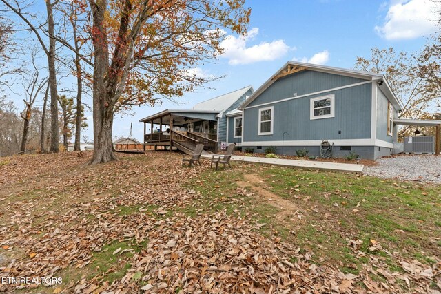 rear view of house featuring central AC and a wooden deck