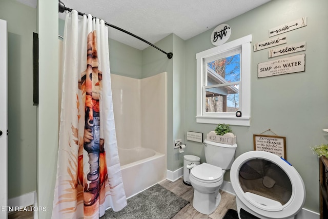 bathroom featuring hardwood / wood-style flooring, shower / bath combination with curtain, toilet, and a textured ceiling