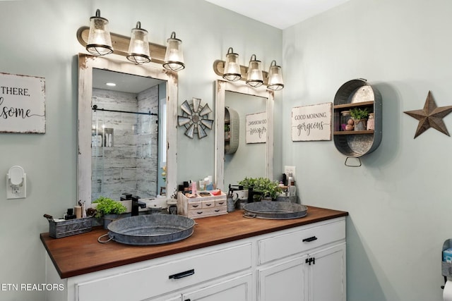 bathroom featuring vanity and a shower with shower door