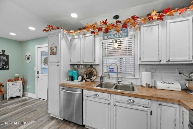 kitchen with white cabinetry, dishwasher, sink, wooden counters, and light wood-type flooring