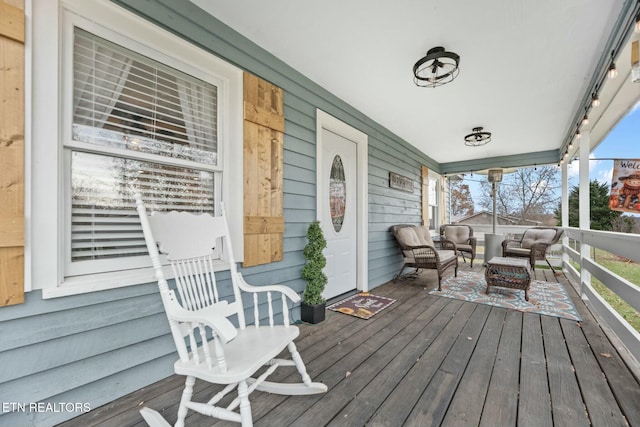 wooden deck featuring covered porch and an outdoor hangout area