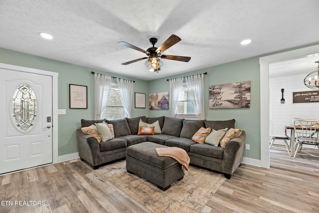 living room with ceiling fan, a healthy amount of sunlight, a textured ceiling, and light hardwood / wood-style floors