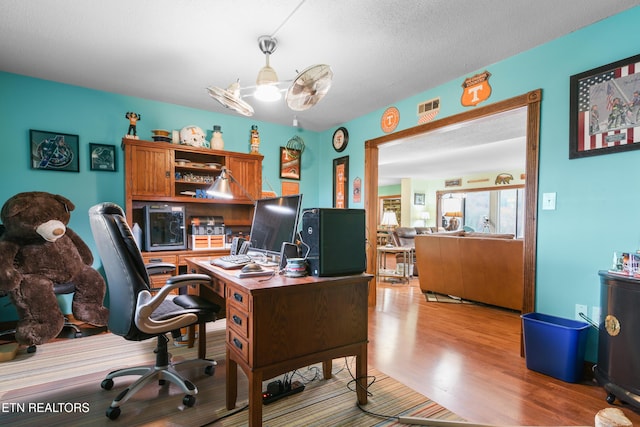 office with a textured ceiling and light hardwood / wood-style flooring