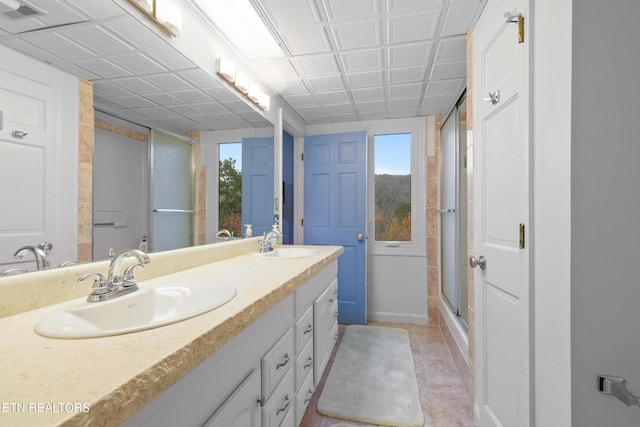 bathroom featuring tile patterned flooring, vanity, and walk in shower