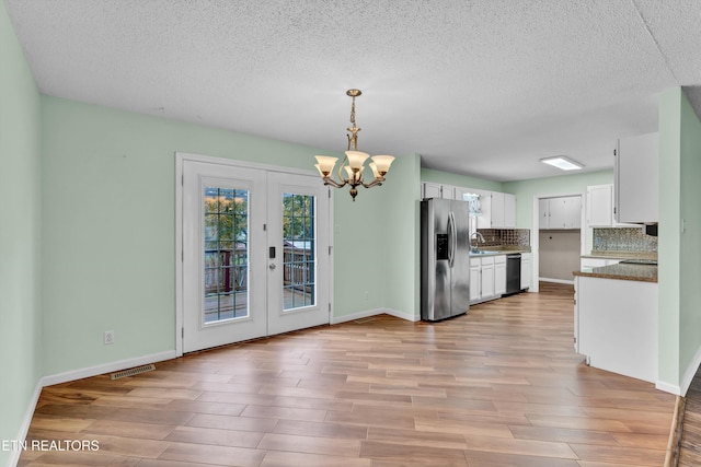 kitchen with french doors, stainless steel appliances, light hardwood / wood-style flooring, white cabinetry, and hanging light fixtures