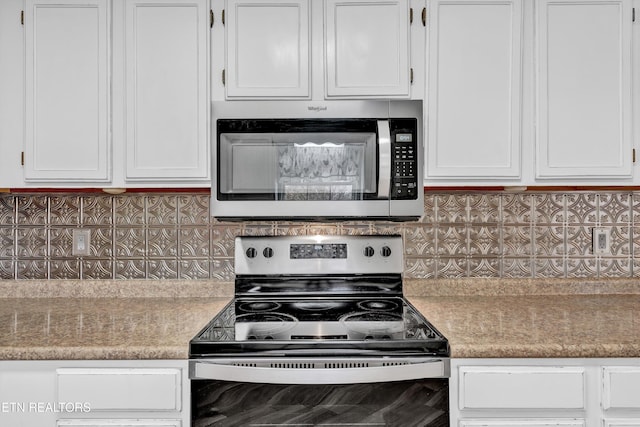 kitchen featuring stainless steel appliances, white cabinetry, and tasteful backsplash