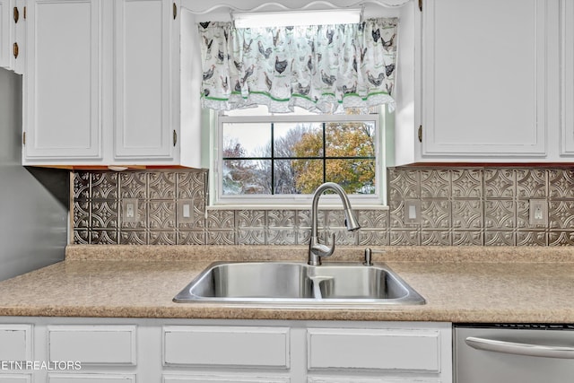 kitchen featuring dishwasher, tasteful backsplash, white cabinetry, and sink