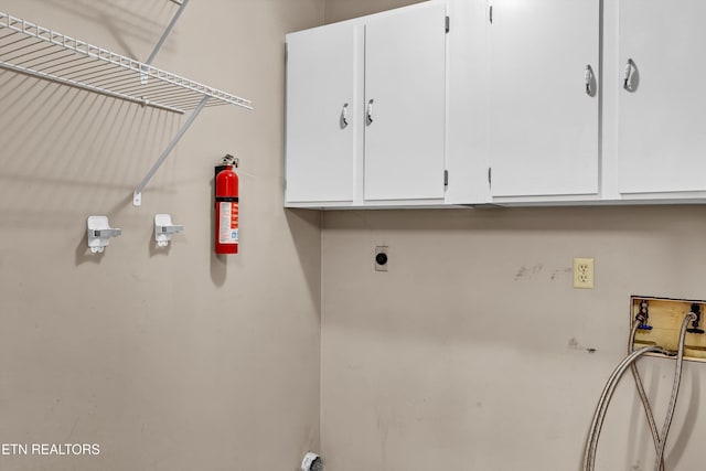 clothes washing area with cabinets and hookup for a washing machine