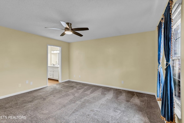 unfurnished room with a textured ceiling, carpet floors, and ceiling fan