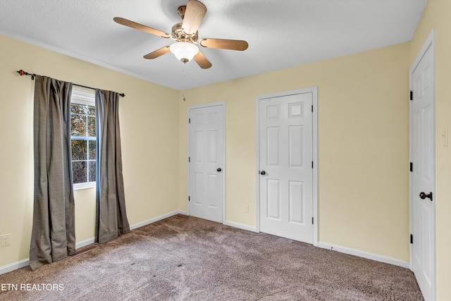 unfurnished bedroom with a textured ceiling, carpet floors, and ceiling fan