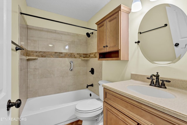 full bathroom with toilet, vanity, a textured ceiling, and tiled shower / bath