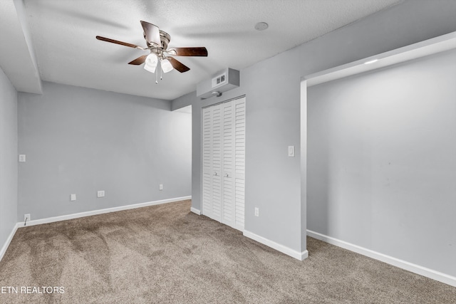 unfurnished bedroom featuring ceiling fan, a closet, carpet, and a textured ceiling