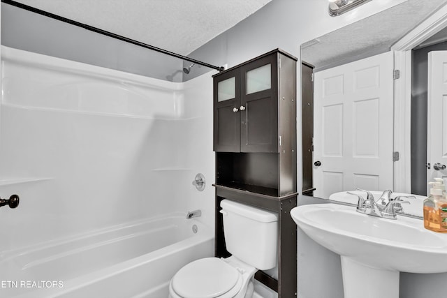 full bathroom featuring a textured ceiling, shower / bath combination, toilet, and sink