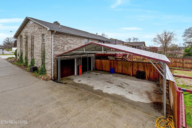 view of home's exterior with a garage and a carport