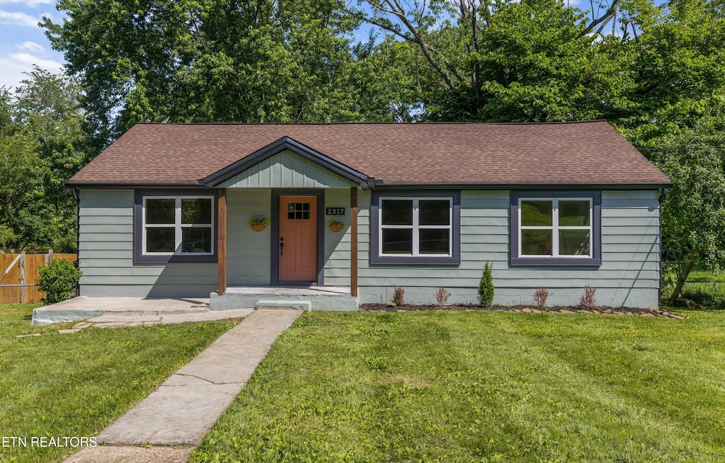 view of front of home featuring covered porch and a front lawn