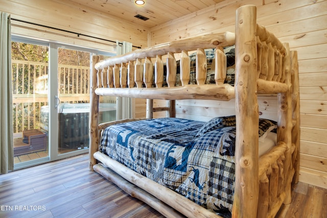 bedroom featuring access to outside, hardwood / wood-style flooring, wood walls, and wood ceiling