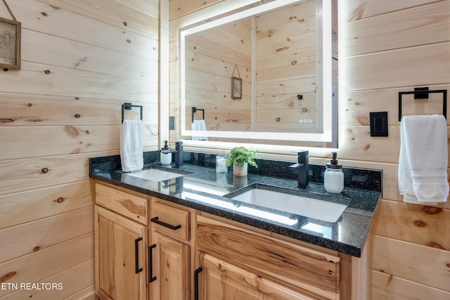 bathroom featuring wooden walls and vanity