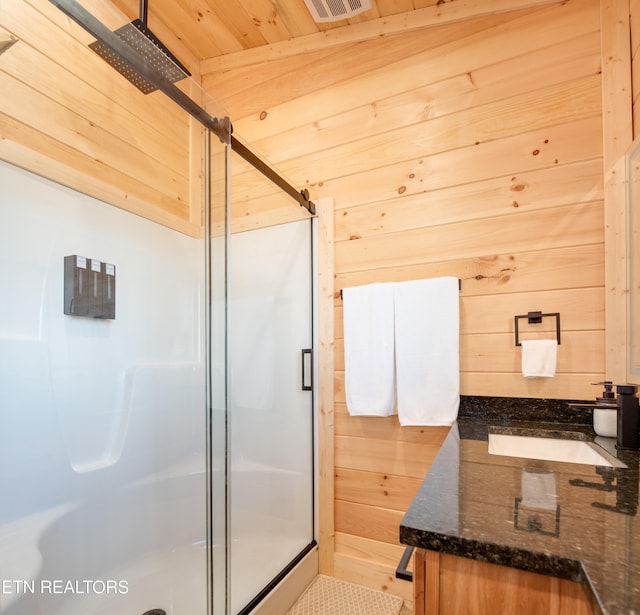 bathroom with wood walls, sink, wooden ceiling, and a shower with shower door